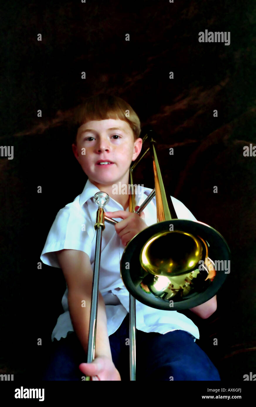 An 11 year old boy playing, or trying to play, the trombone. The