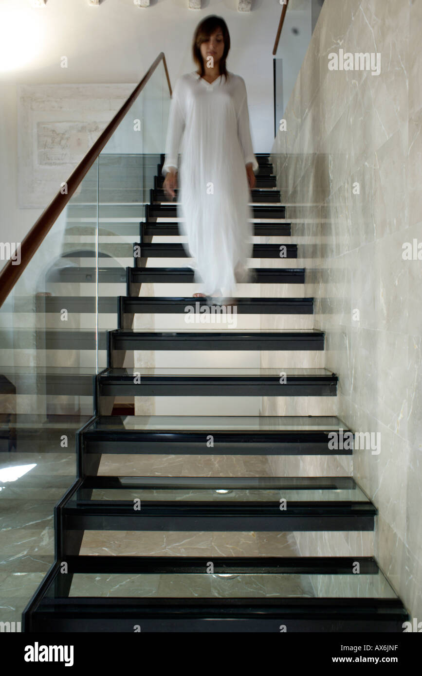 Ghosted image of woman walking down stairs Stock Photo