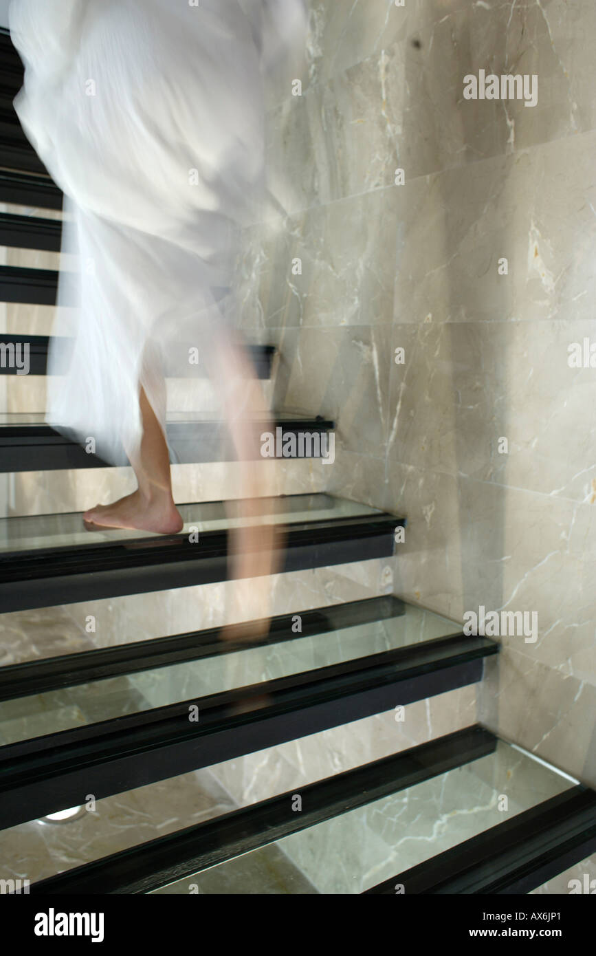 Ghosted image of woman walking up stairs (cropped to show lower body) Stock Photo