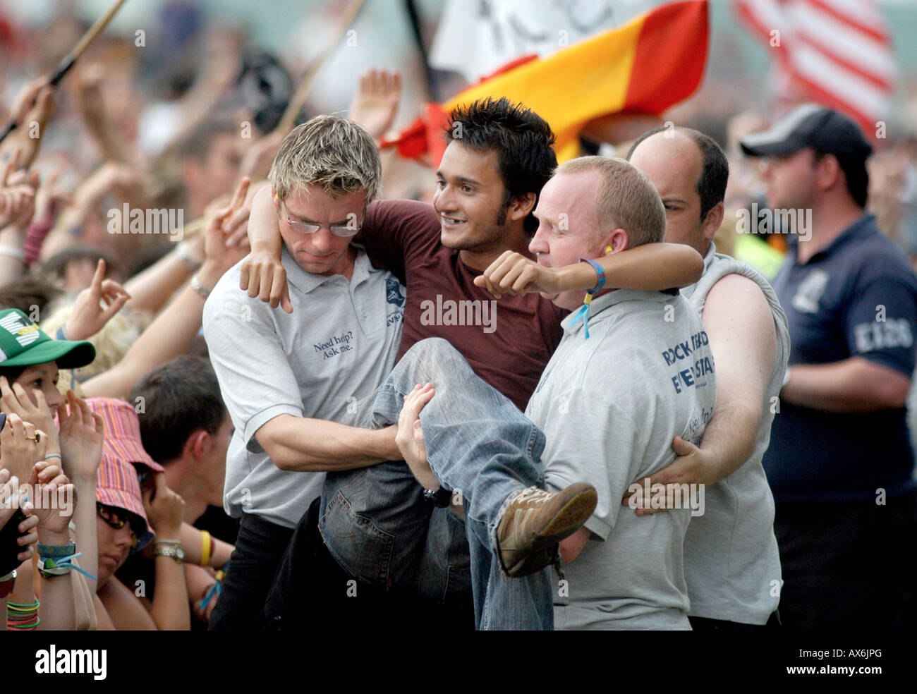 Security help a fan from the crowd in to the pit at T in the Park music festival Stock Photo