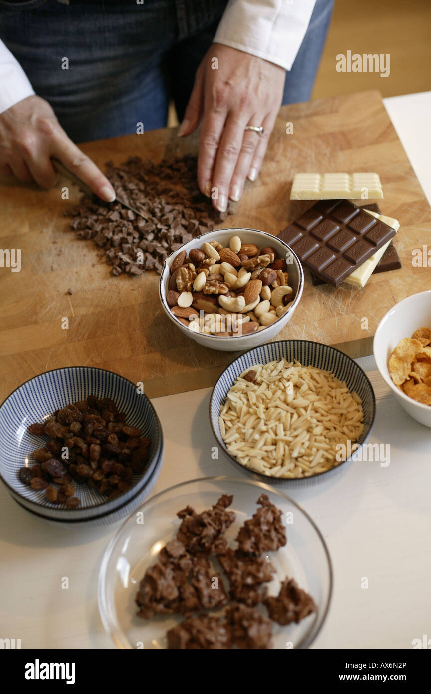 High angle view of woman cutting chocolate with knife on cutting board Stock Photo