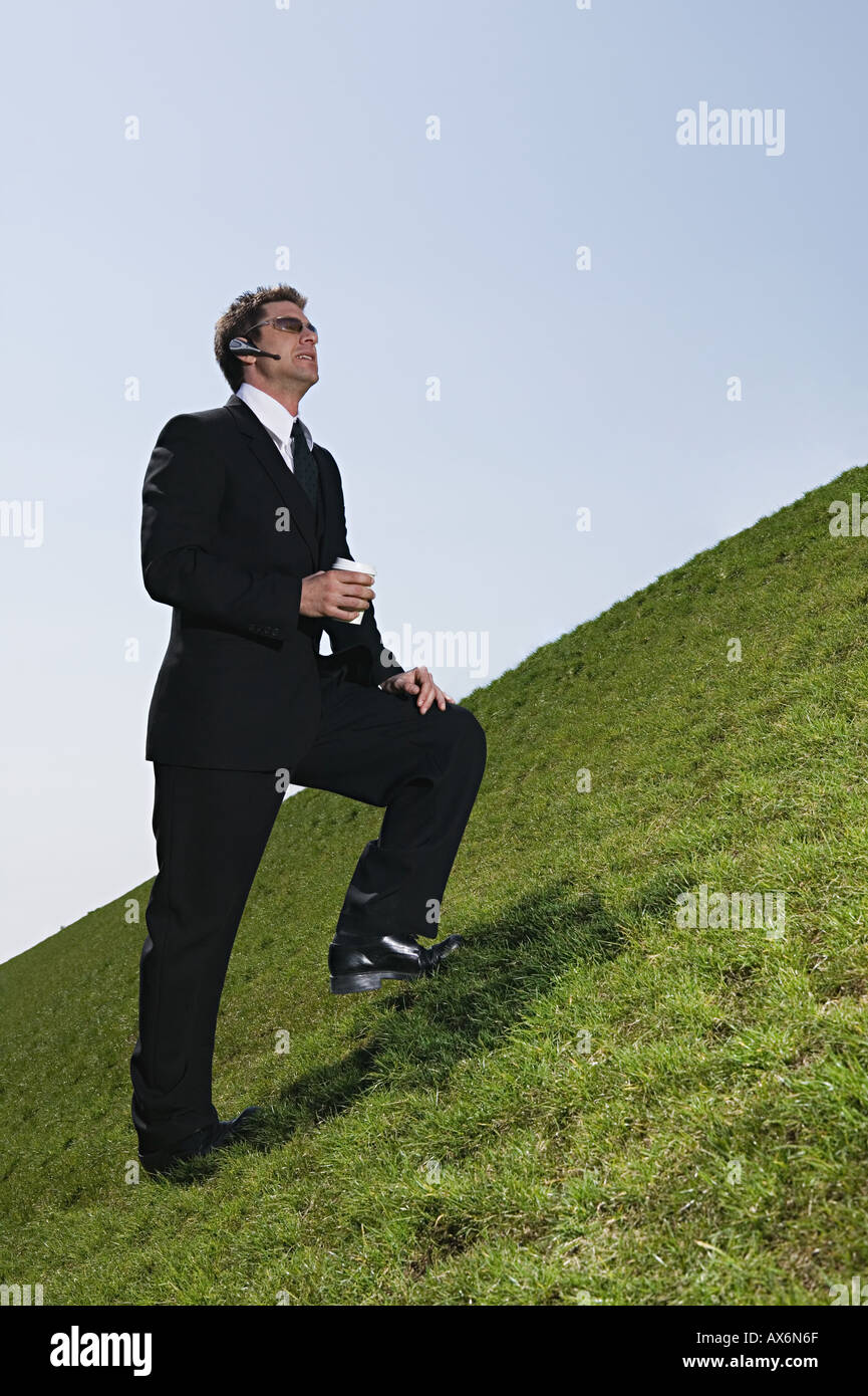 Businessman on steep hill Stock Photo