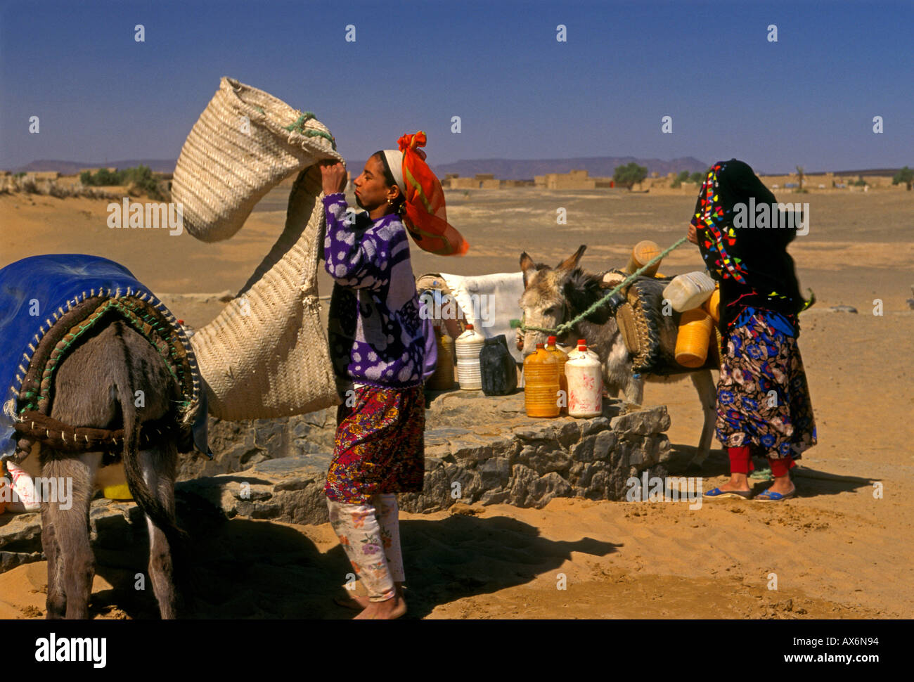 Moroccans, Berbers, girl drawing water from well, town of Merzouga, Merzouga, Errachidia Province, Morocco, Africa Stock Photo