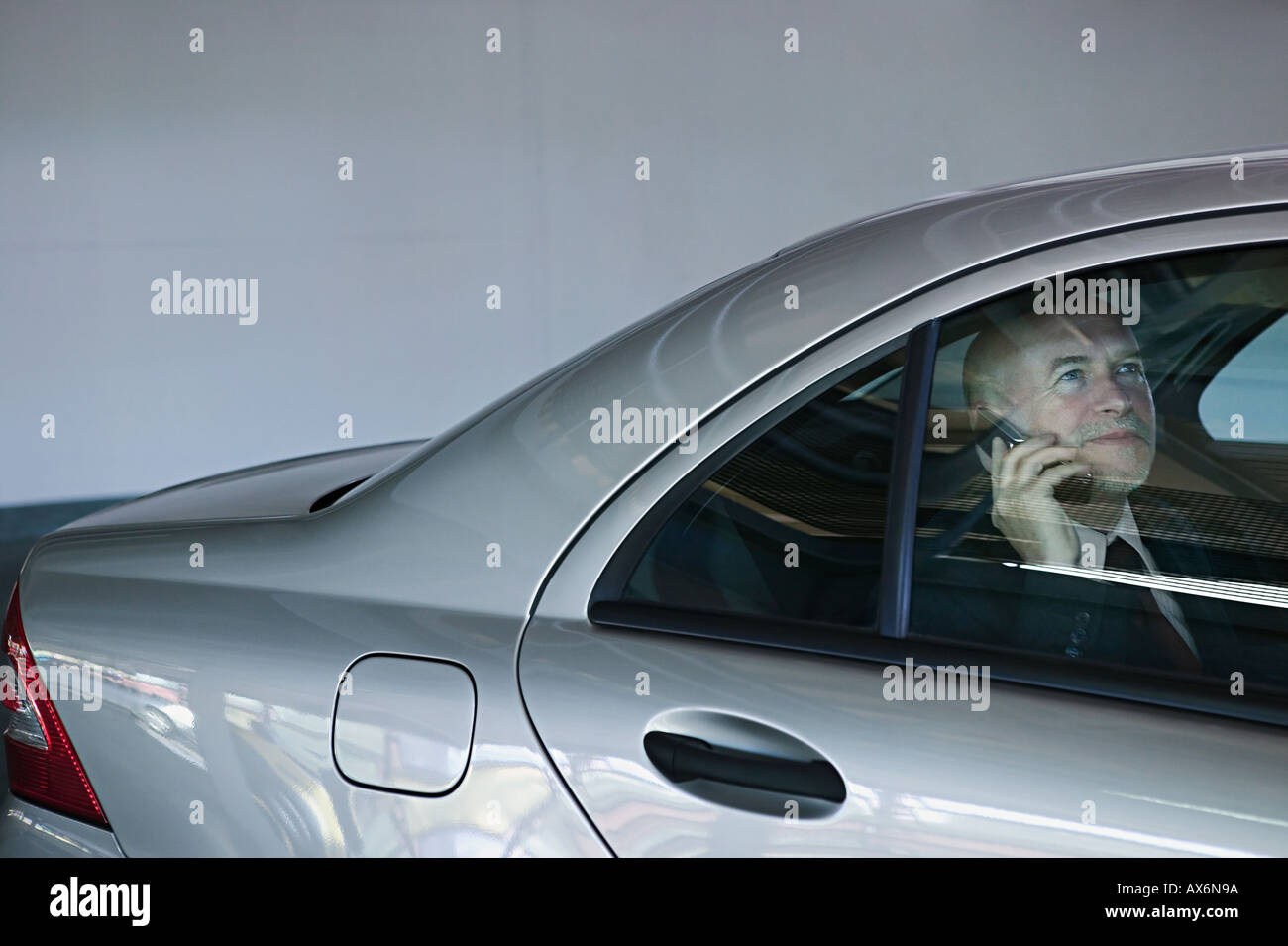 Businessman in a car using mobile phone Stock Photo