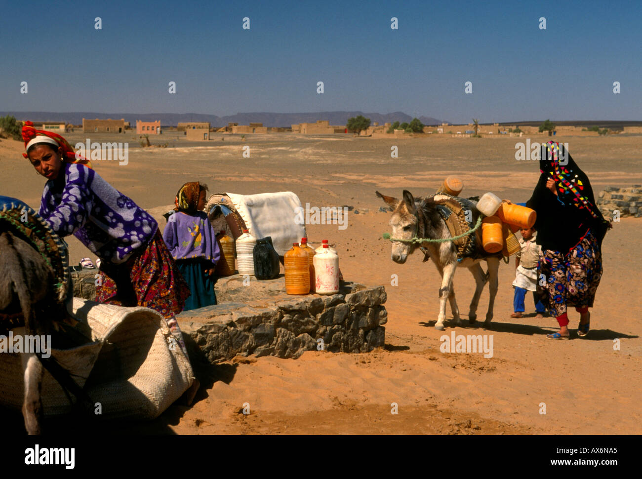 Moroccans, Berbers, girl drawing water from well, town of Merzouga, Merzouga, Errachidia Province, Morocco, Africa Stock Photo