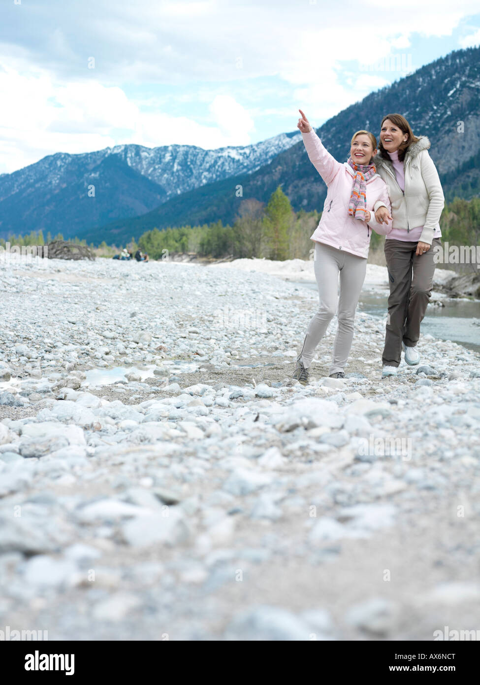 Two young women walking at riverbank Stock Photo - Alamy