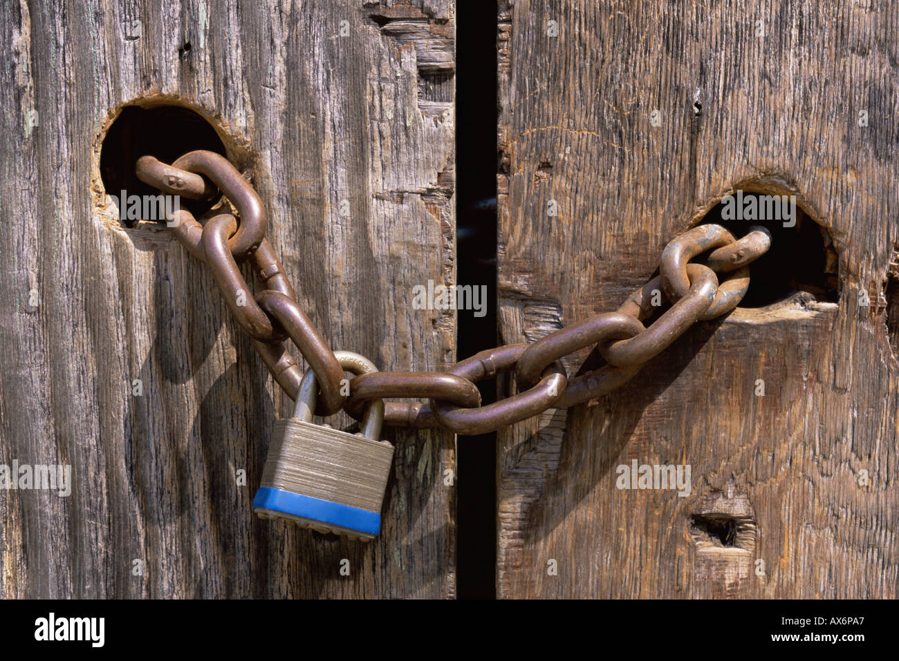 Lock and chain through wooden door Stock Photo Alamy