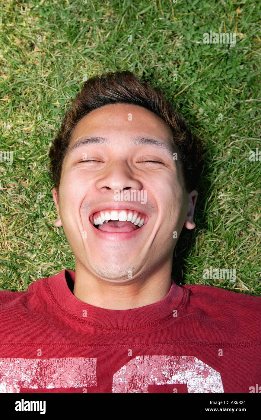 Man lying on grass and laughing Stock Photo Alamy