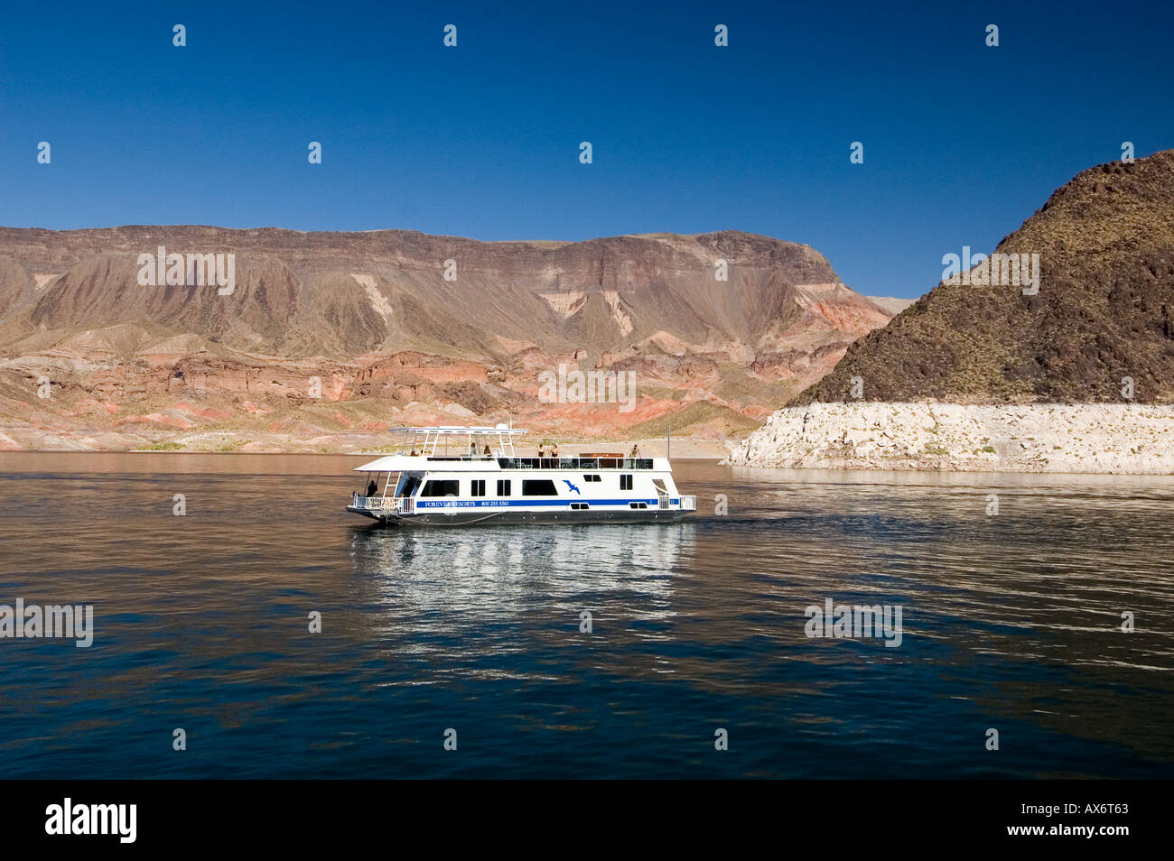 Houseboat cruising Lake Mead against Red Mountain backdrop, Nevada