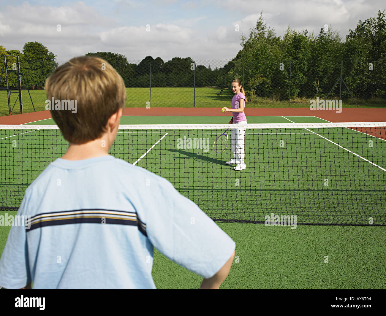 Boy and girl playing tennis Stock Photo