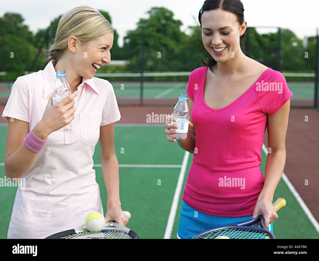 Women having fun on tennis court Stock Photo