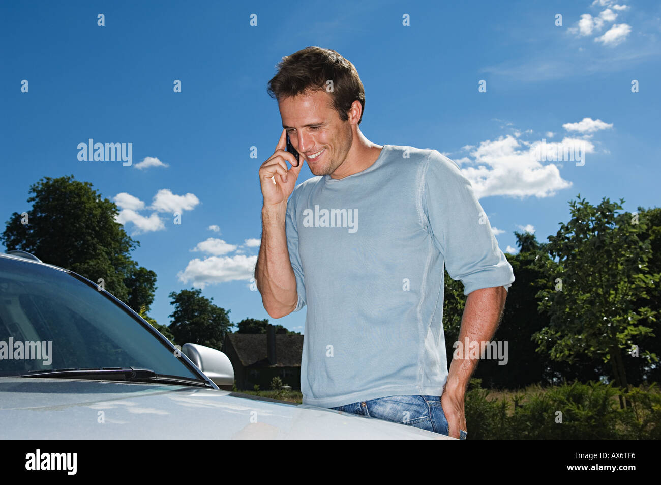 Man in mobile phone by his car Stock Photo