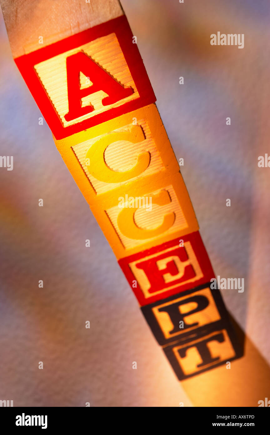 STACK OF WOODEN TOY BUILDING BLOCKS SPELLING THE WORD ACCEPT Stock Photo