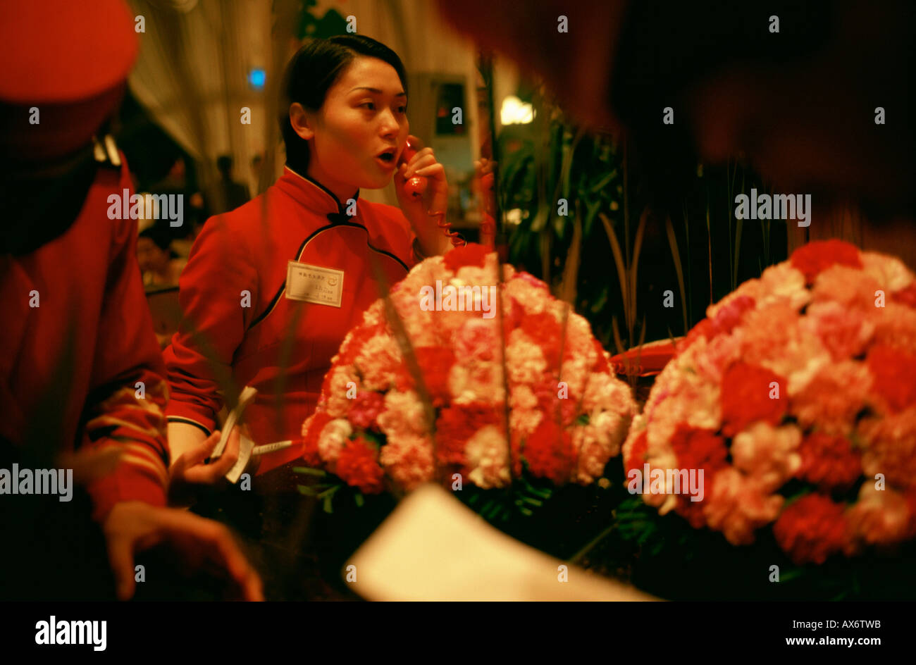 A female Chinese waitress on the phone in a fish restaurant in Wuhan Stock Photo