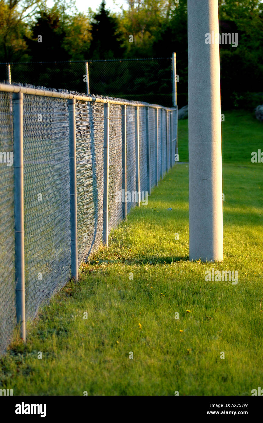 A chain link fence that circles a baseball field Stock Photo