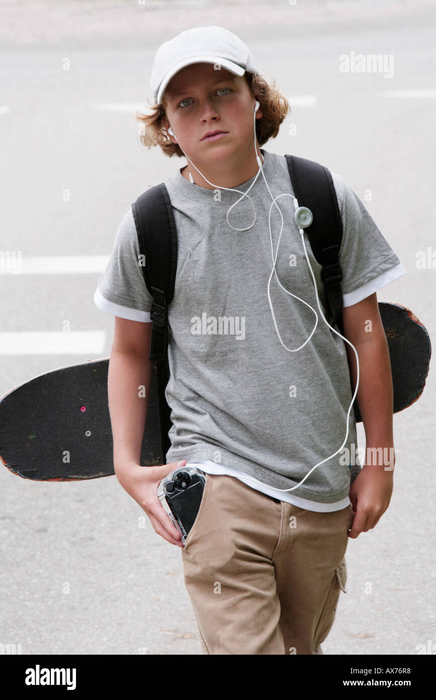 Close-up of a boy carrying a skateboard and a backpack Stock Photo - Alamy
