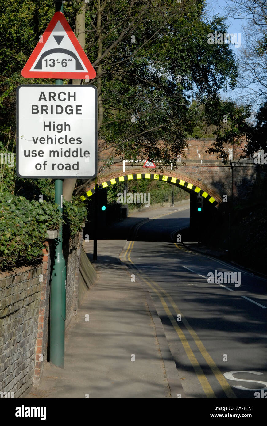 Low arch bridge warning sign and high visibility markings, Cheam, south London, Surrey, England Stock Photo