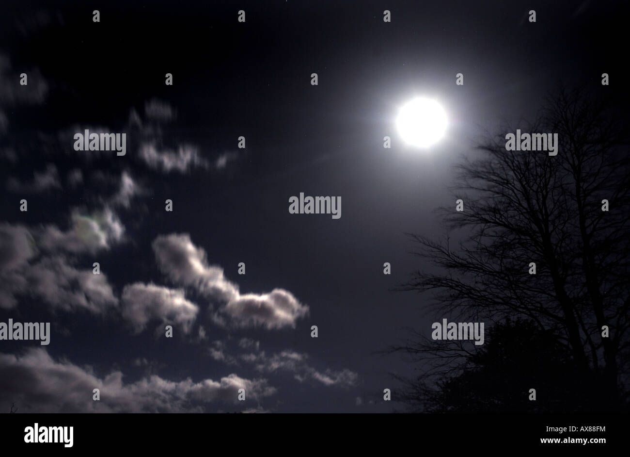 Moon (at the vernal equinox) peeping out from behind beautiful clouds Stock Photo