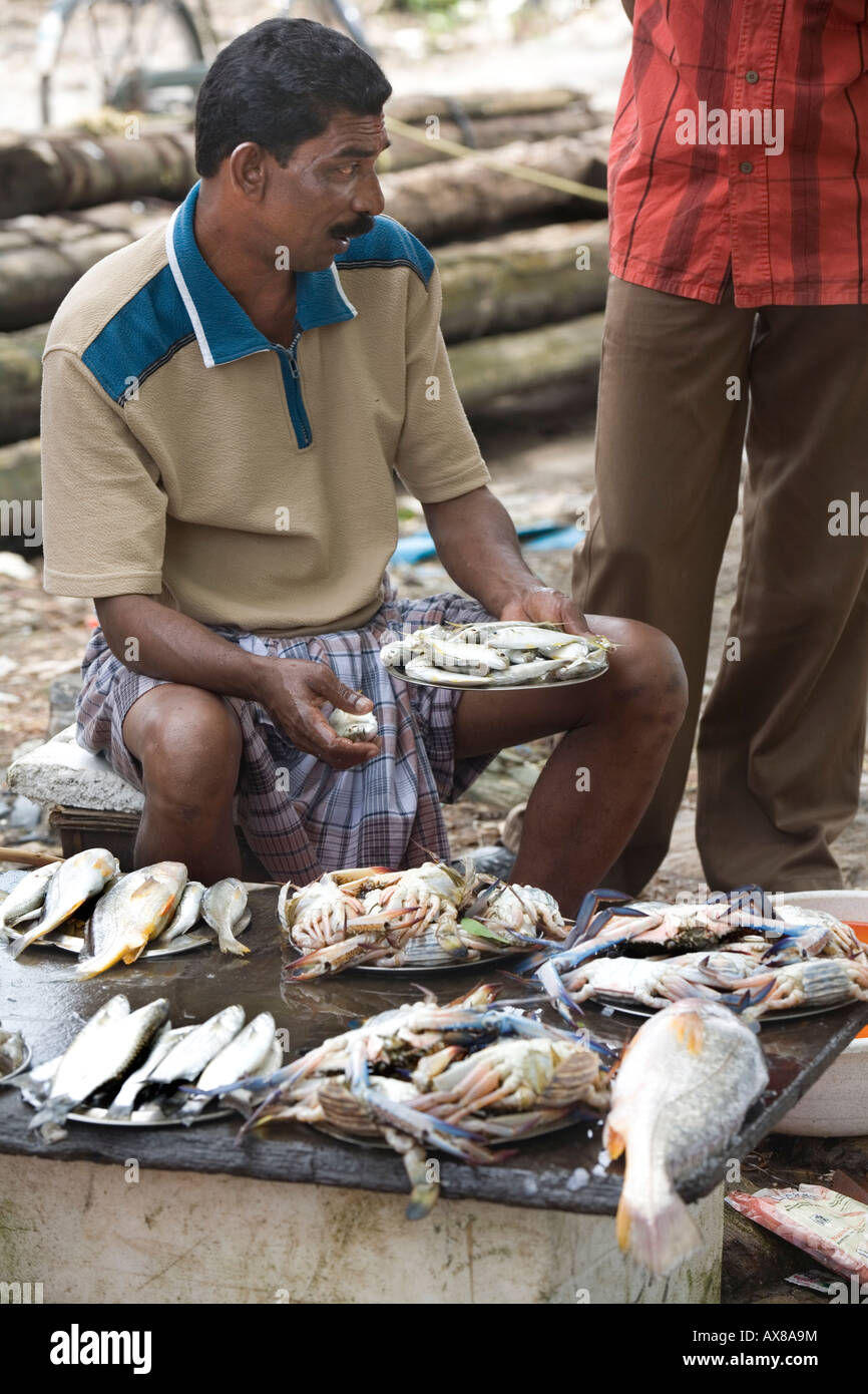 Keralite fishmonger displaying fresh fish at the quay. Open air fish market Fort kochi Beach Cochin Kerala South India Stock Photo