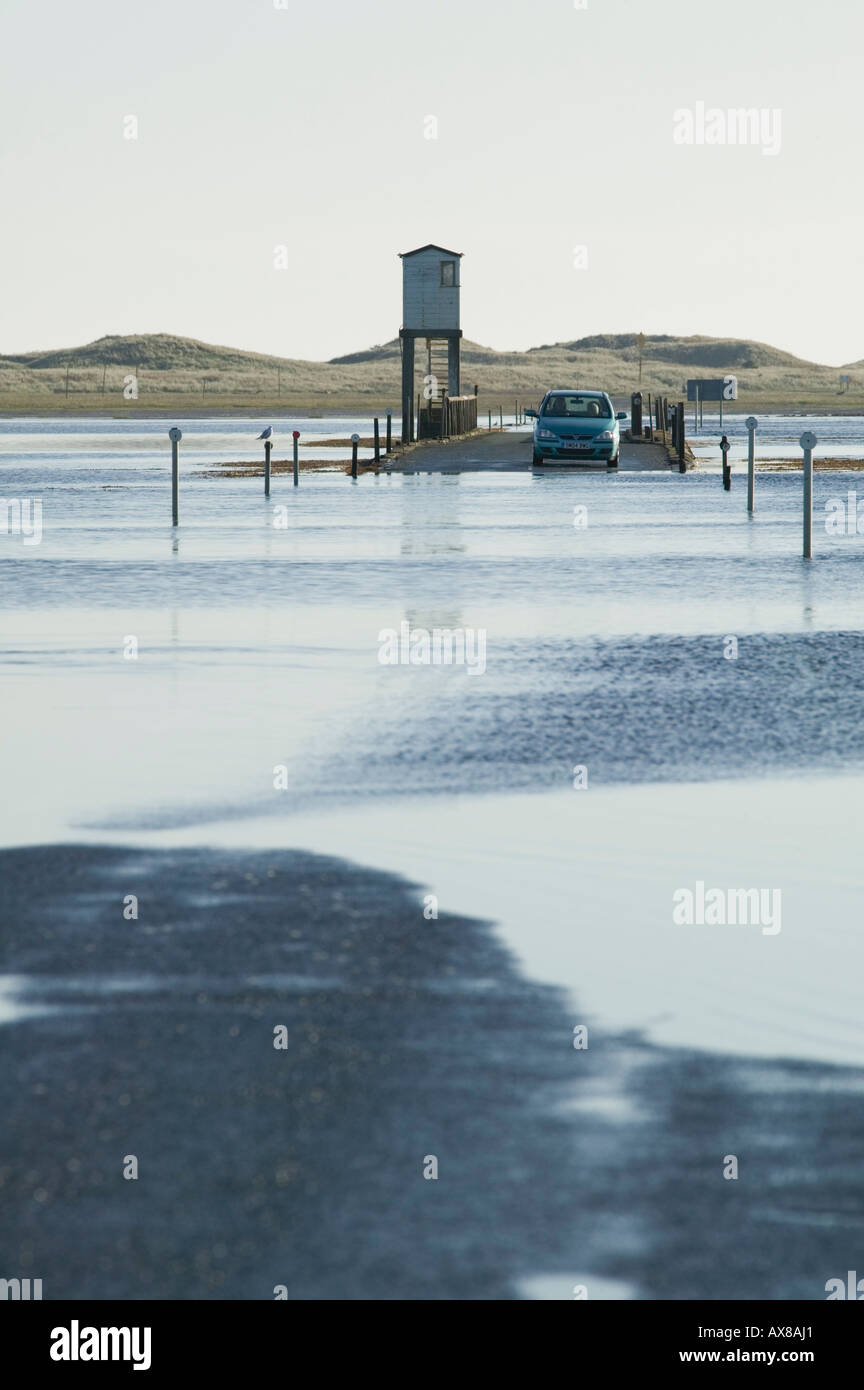 A car stranded on the causeway connecting Holy Island to the Mainland, Northumberland, England Stock Photo