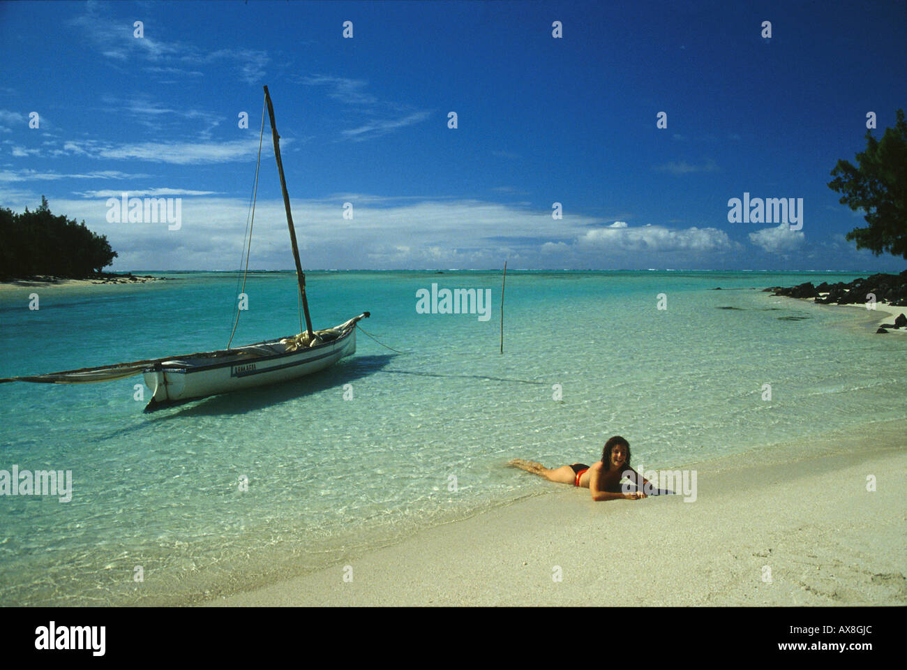 Frau am Strand mit Boot, Ile aux Cerfs, Mauritius Stock Photo