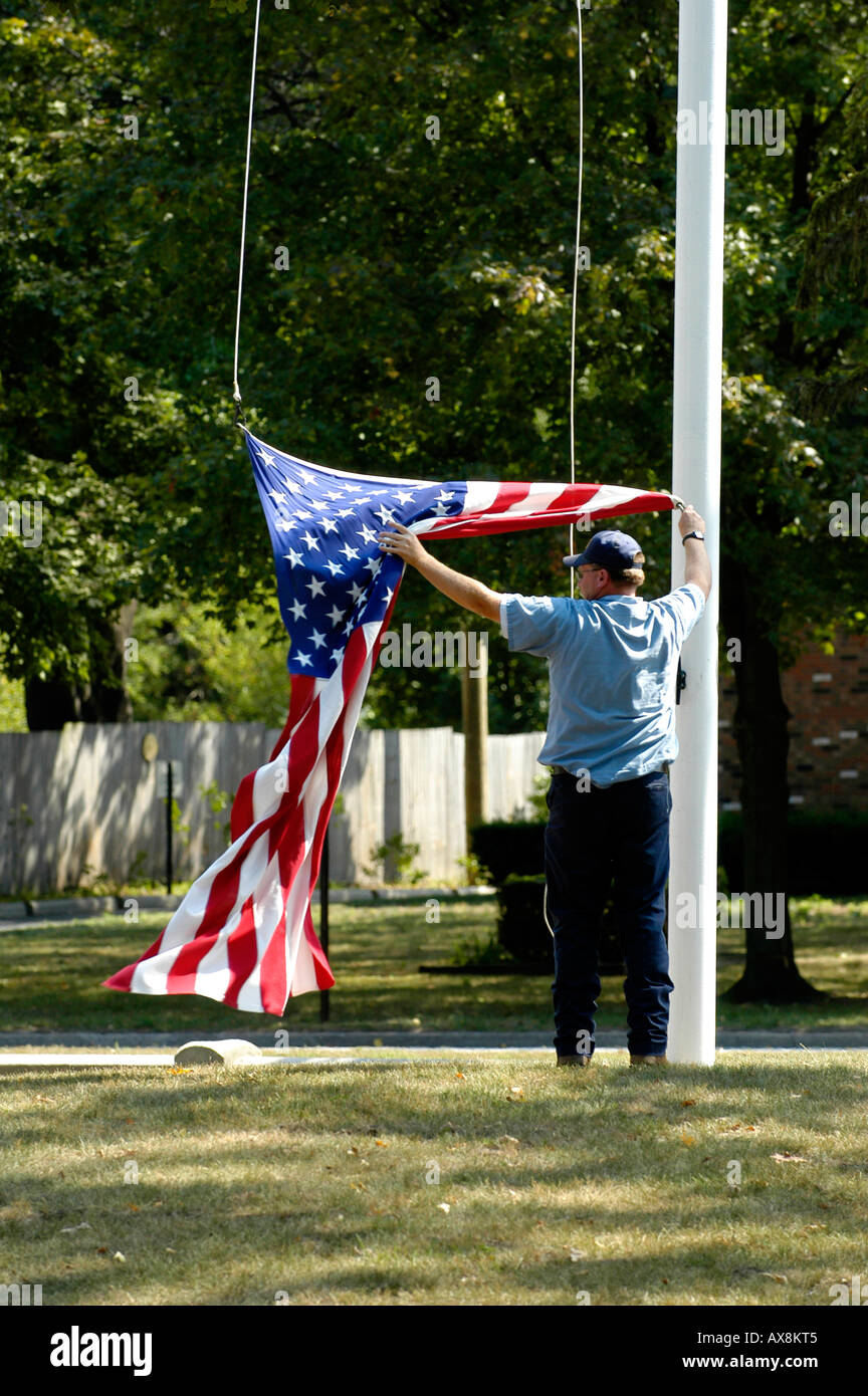 Lowering the flag at the end of the day being careful not to let it