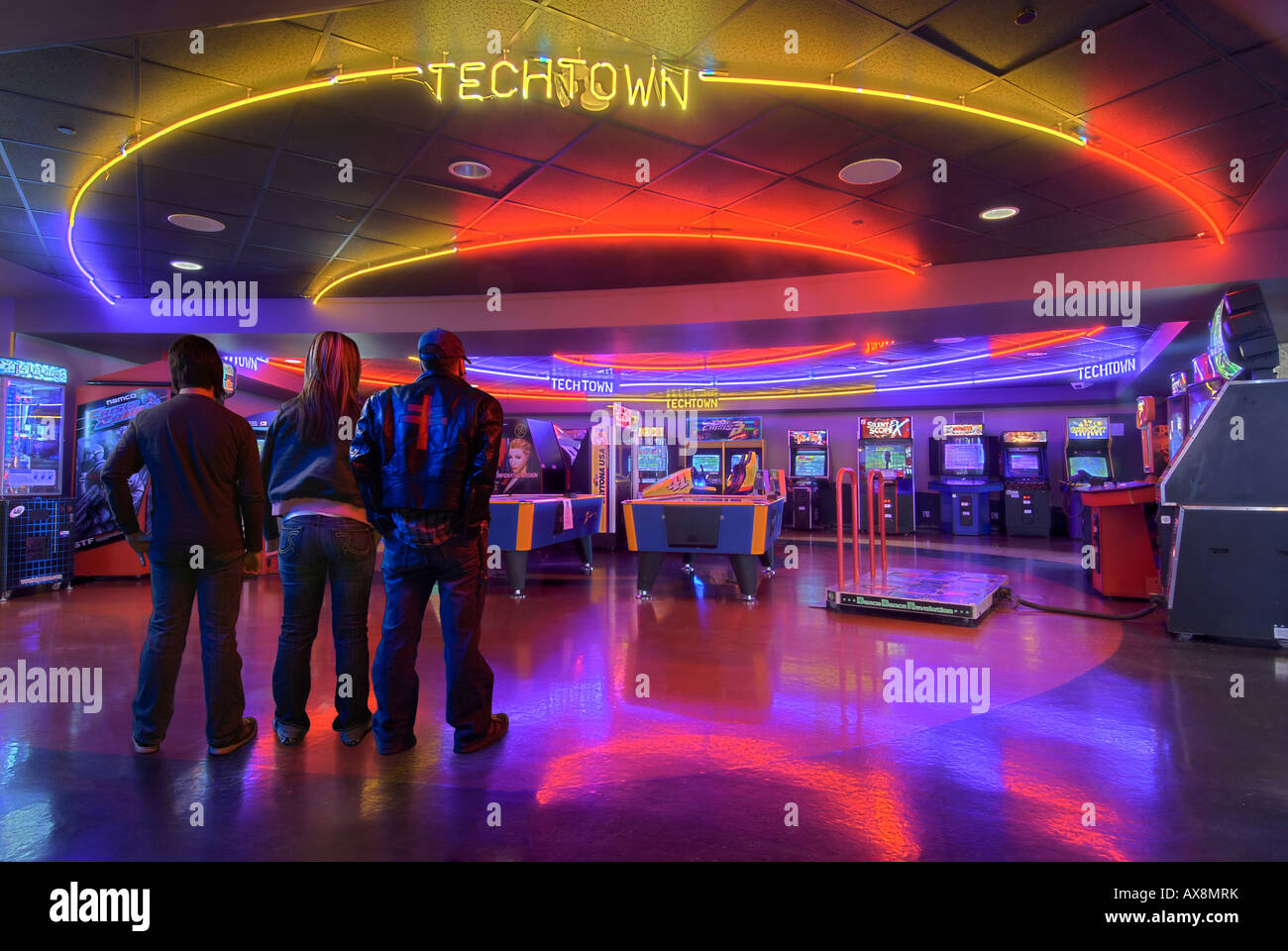 A group of friends contemplate what games to play first in the vibrant and colourful Techtown arcade Stock Photo