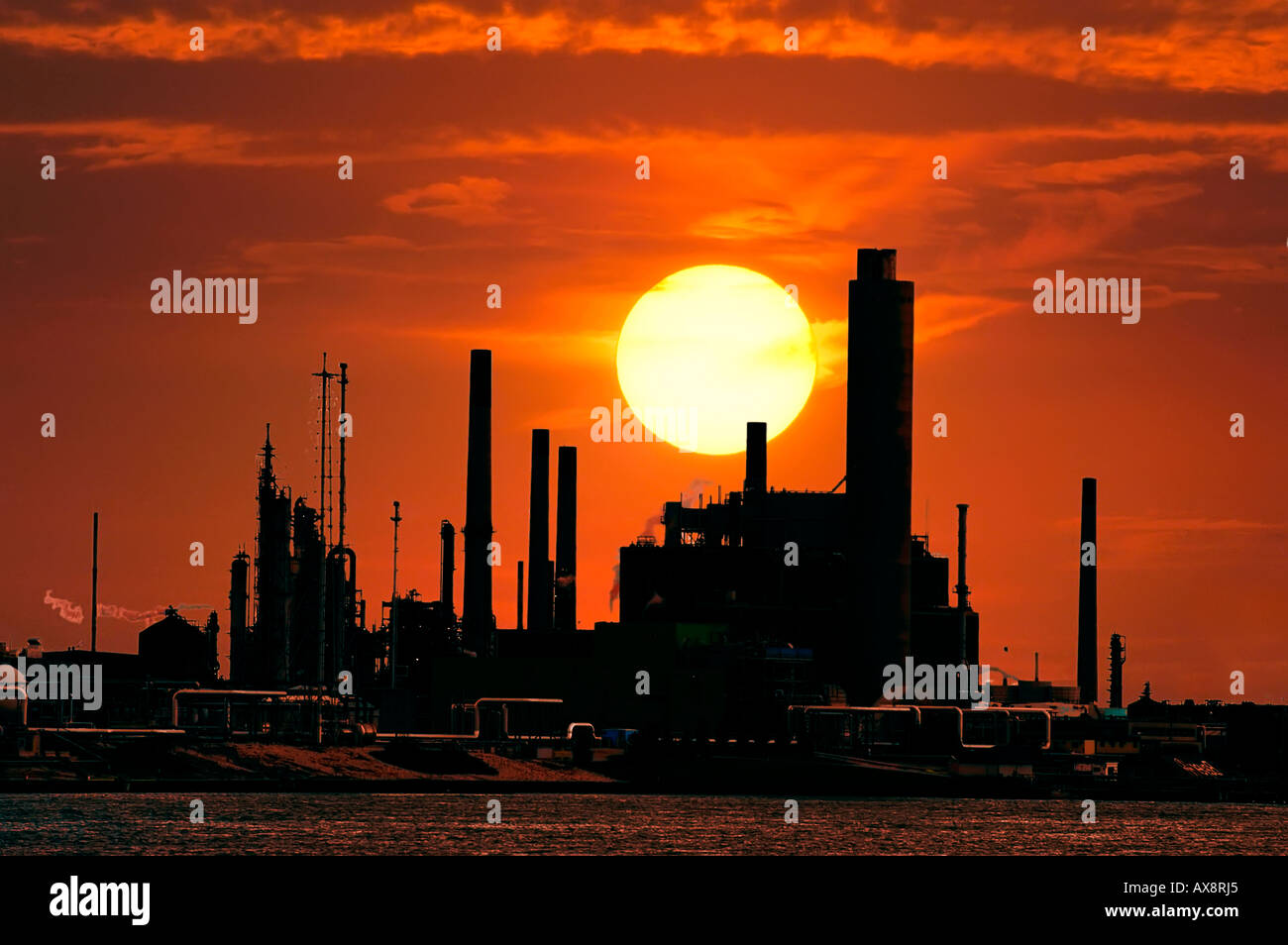 Sun set behind an industrial complex Stock Photo