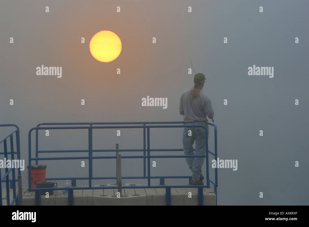 Fisherman at dawn in the fog and mist Stock Photo