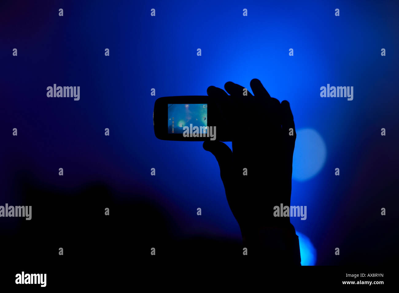 hand in the air in the crowd taking video with a mobile phone at a dance event in Belfast Northern Ireland Stock Photo
