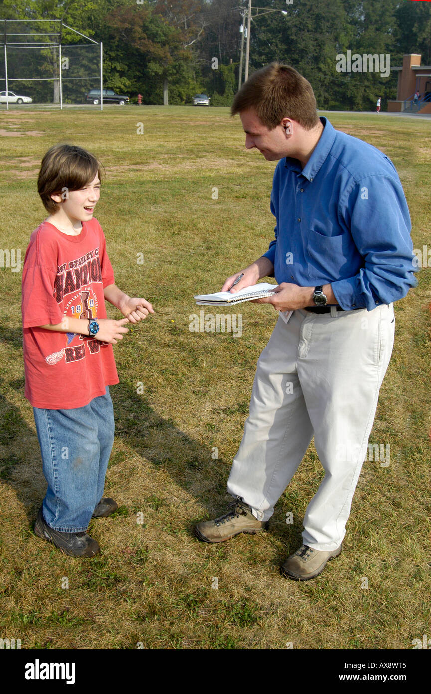Newspaper reporter interviews a 7th grade Middle School boy student Stock Photo