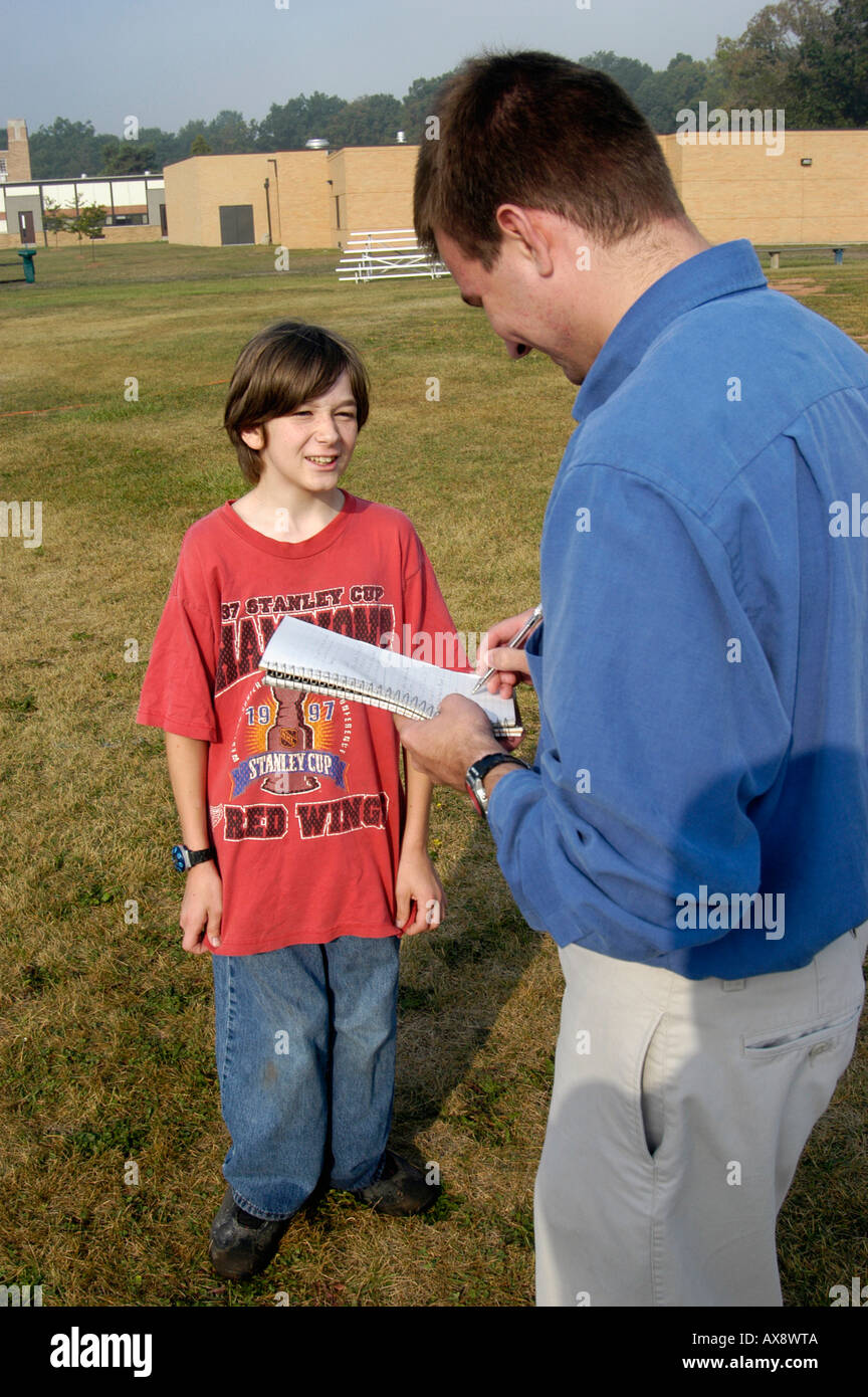 Newspaper reporter interviews a 7th grade Middle School boy student youngster Stock Photo