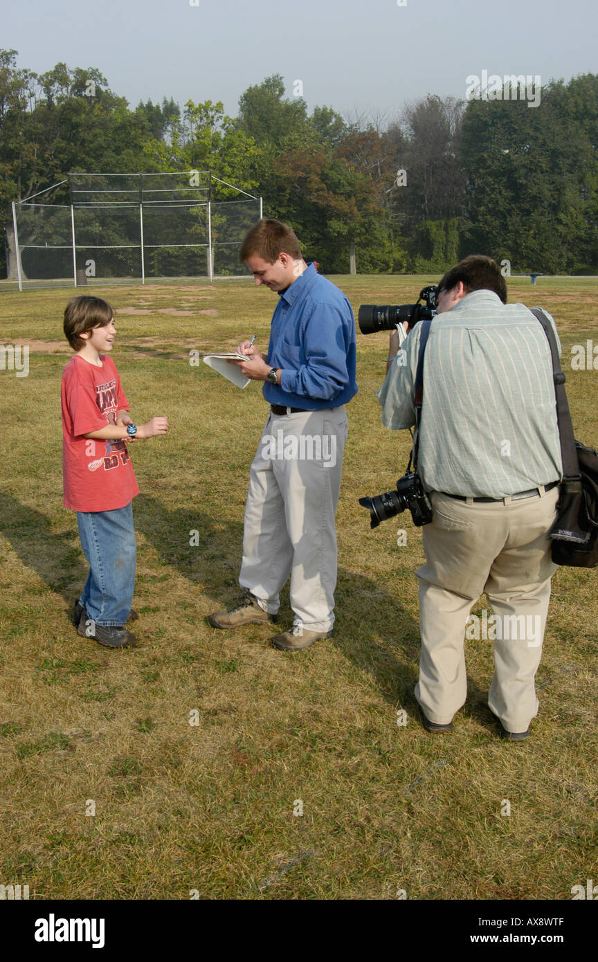 Newspaper reporter interviews a 7th grade middle School boy student Stock Photo