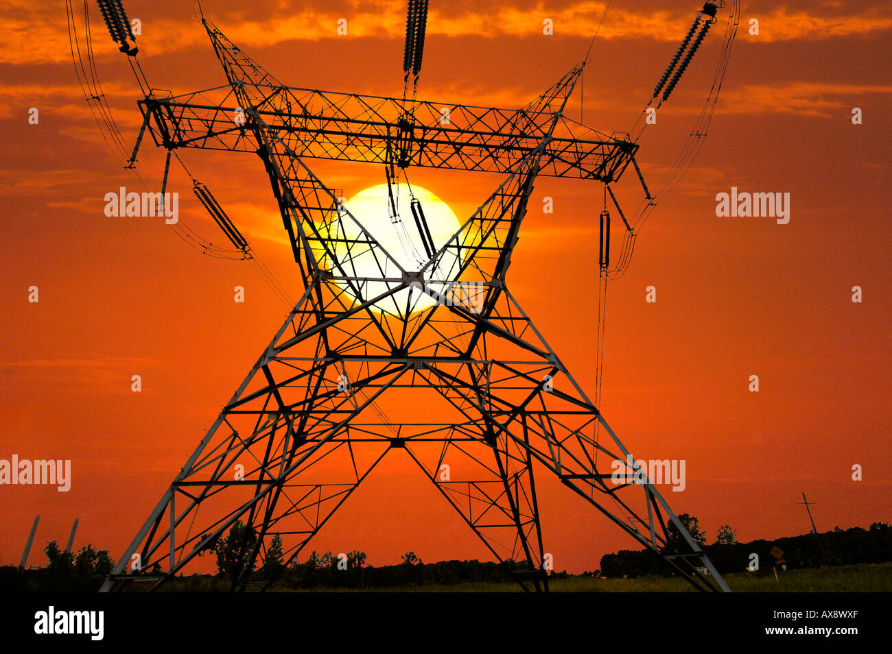 Power lines against a setting sun Stock Photo