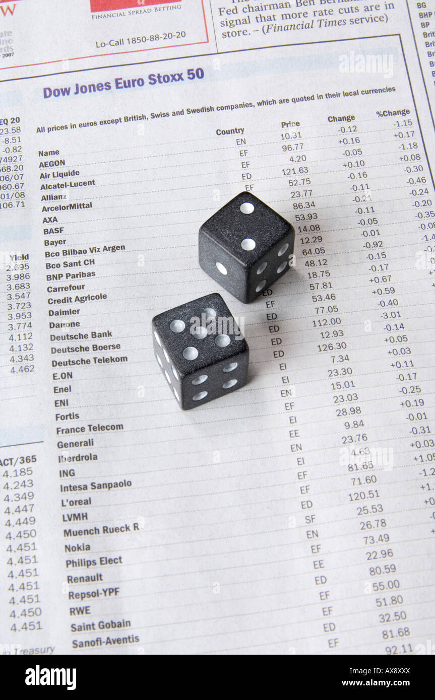 A pair of black dice sitting on a newspaper column of international stock prices (stocks and shares) (Dow Jones Euro Stoxx 50) Stock Photo