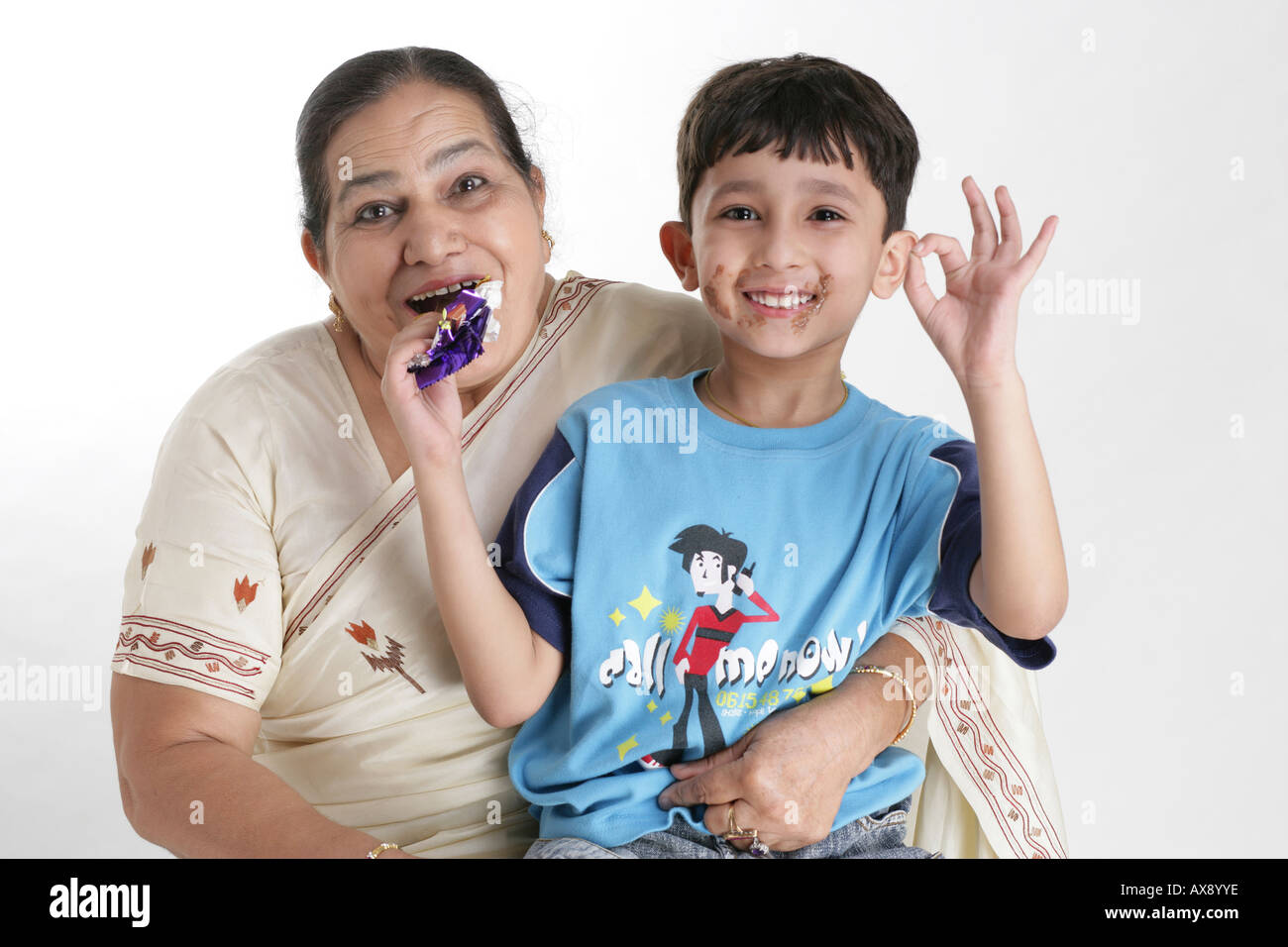 Portrait of a senior woman and her grandson eating chocolate and smiling Stock Photo