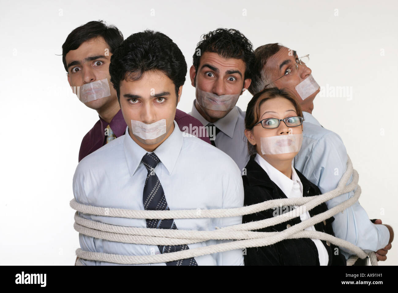 Portrait of five business people tied up with ropes Stock Photo