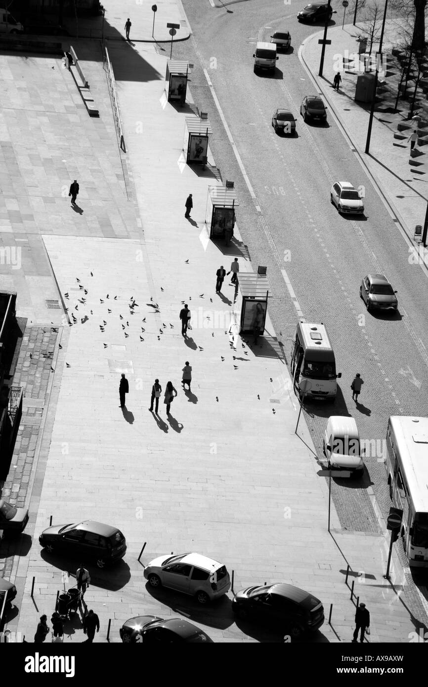 Street in Porto Portugal with people pigeons and bus stops Stock Photo