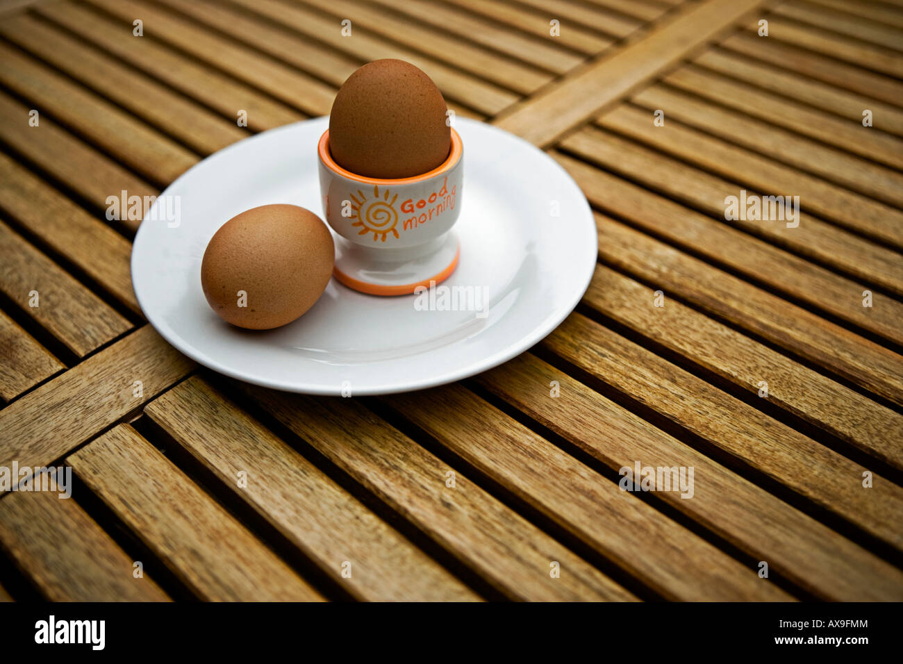 Two boiled eggs in egg cup on wooden table Stock Photo