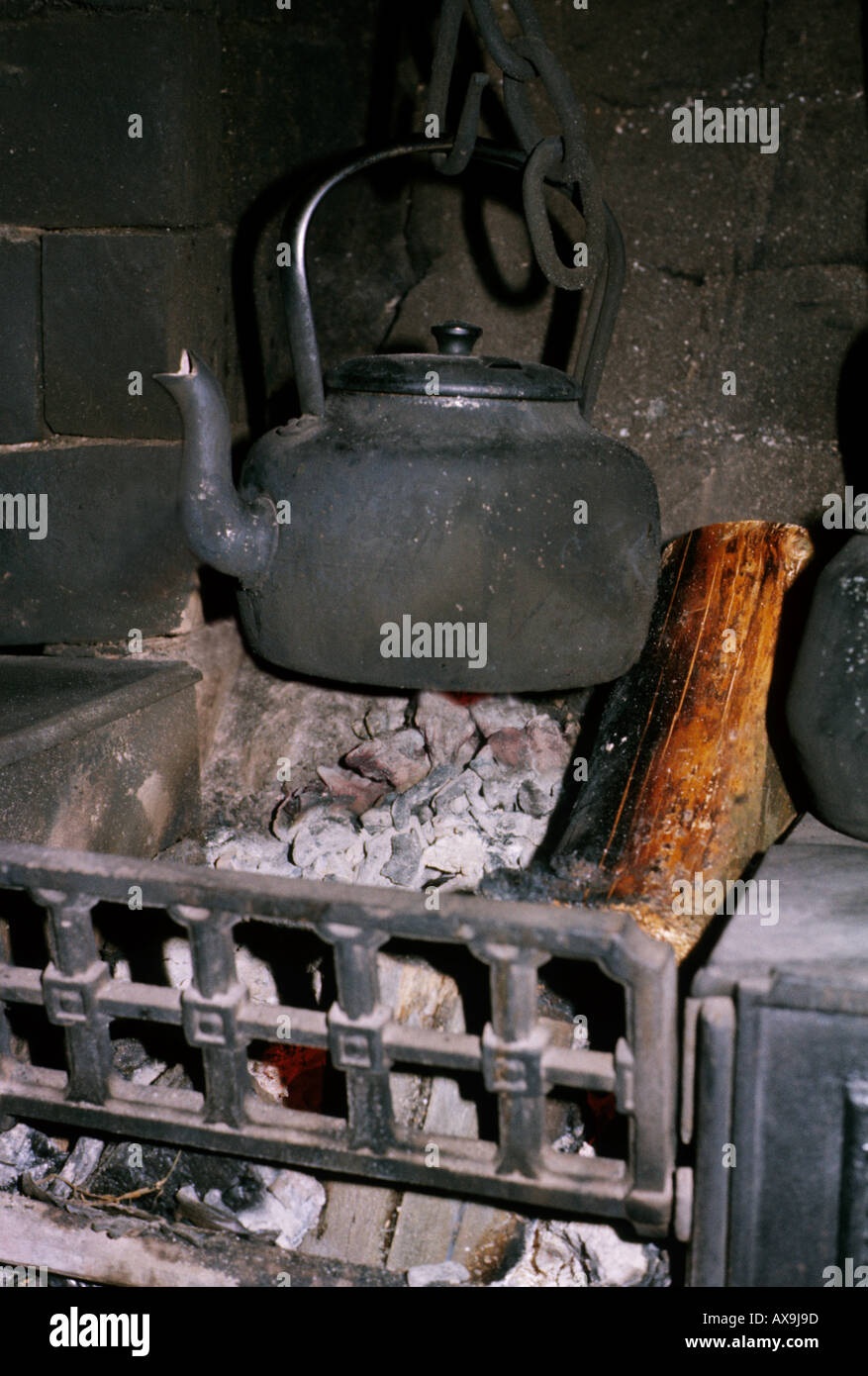 Blackened kettle hanging over embers in an open fire in a Welsh house