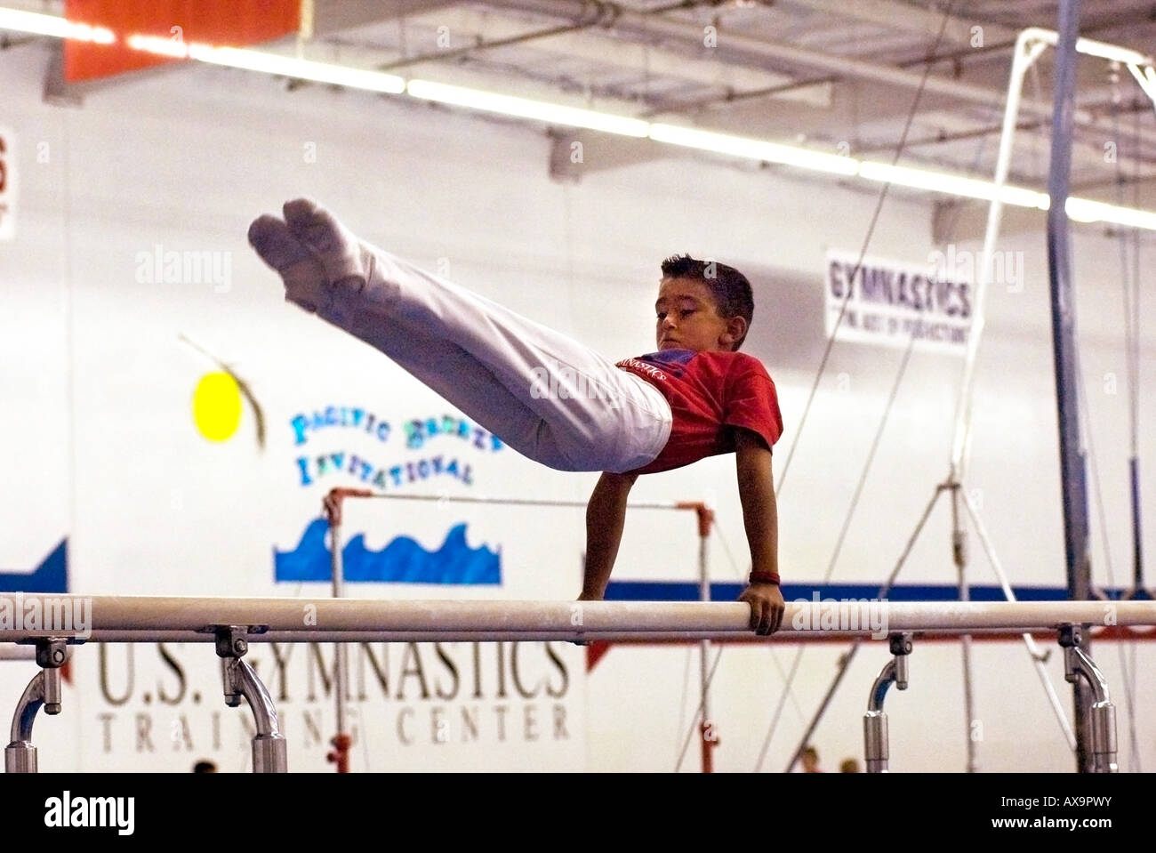 Boy performs on gymnastics parallel bars during demonstration meet at U