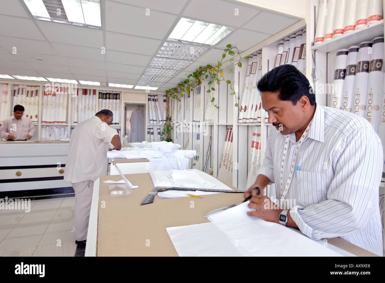 A fabric merchant cutting material for an outfit in Doha, Qatar Stock