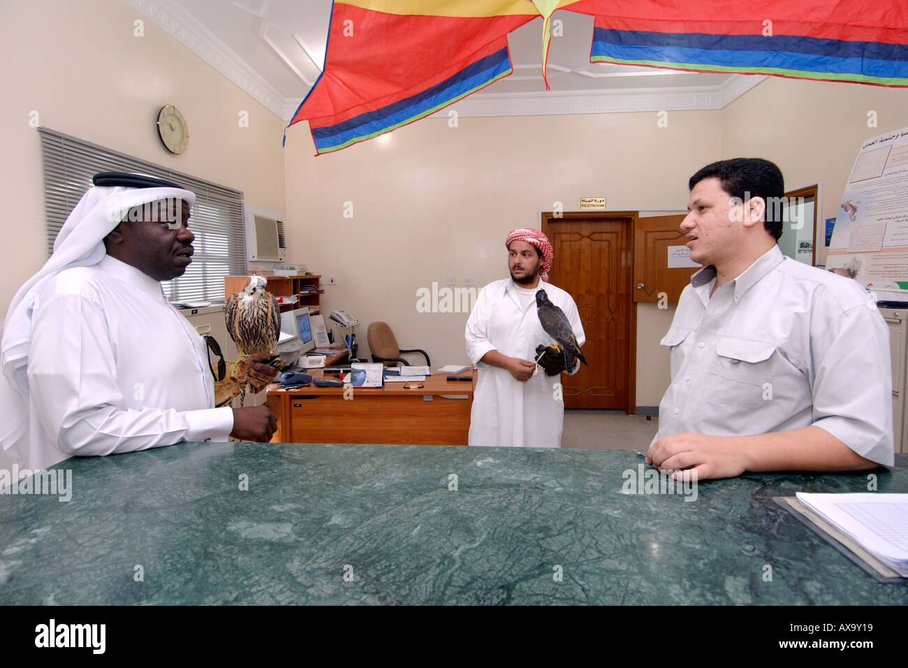 Qataris with their falcons talking to a vet in the waiting room of the