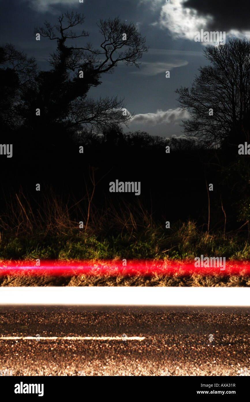 Car's headlights and brake lights / tail lights caught in light stream on moonlit night Stock