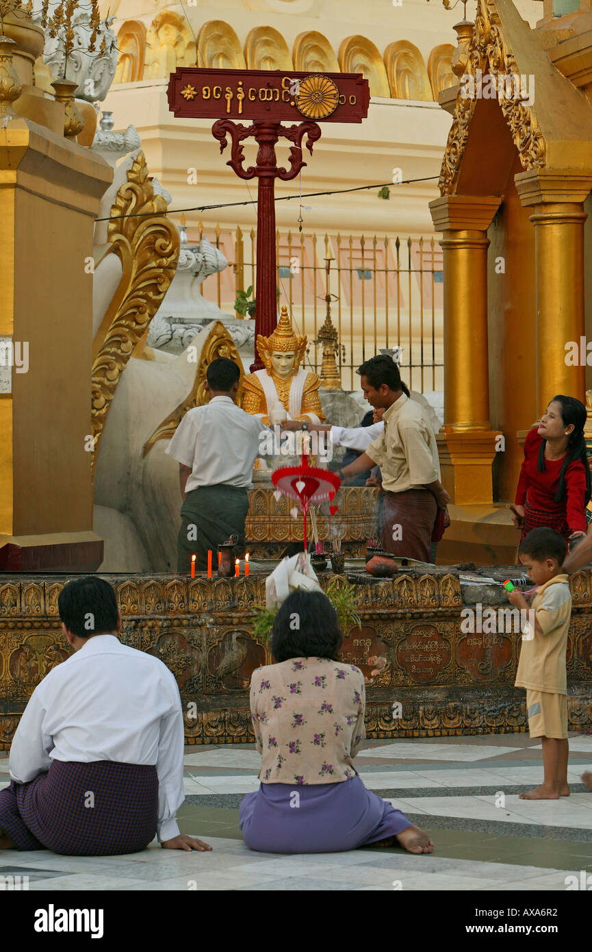 Shwedagon Pagoda, Burma, Myanmar, Burmese praying, An den roten Pfosten werden die acht Planetengoetter verehrt Stock Photo