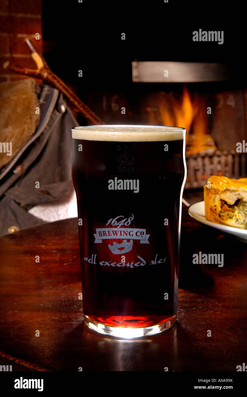 A pint of real ale at the fireside in a country pub in the heart of Sussex.Picture by Jim Holden. Stock Photo