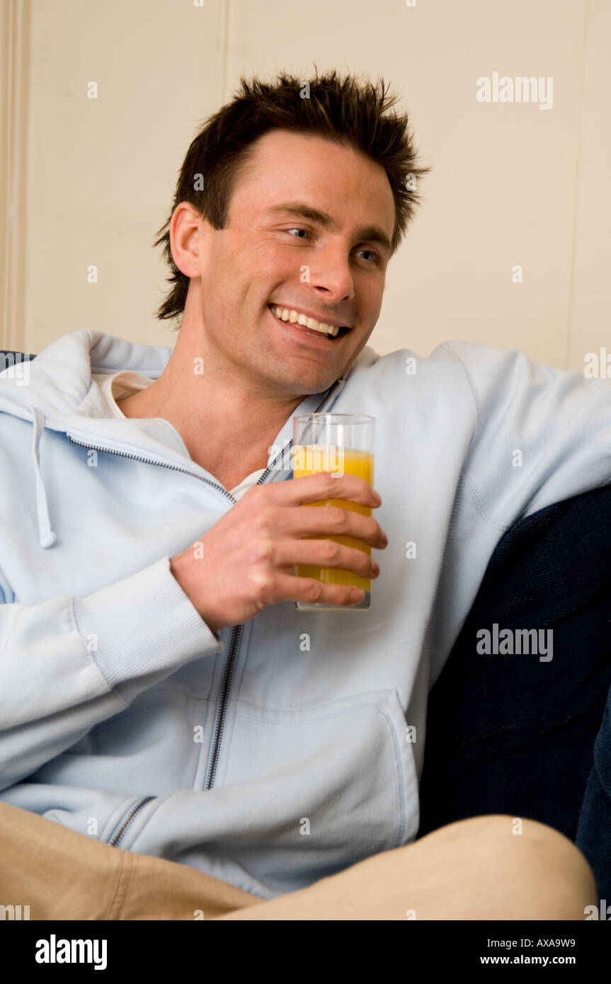 man drinking fresh orange juice Stock Photo
