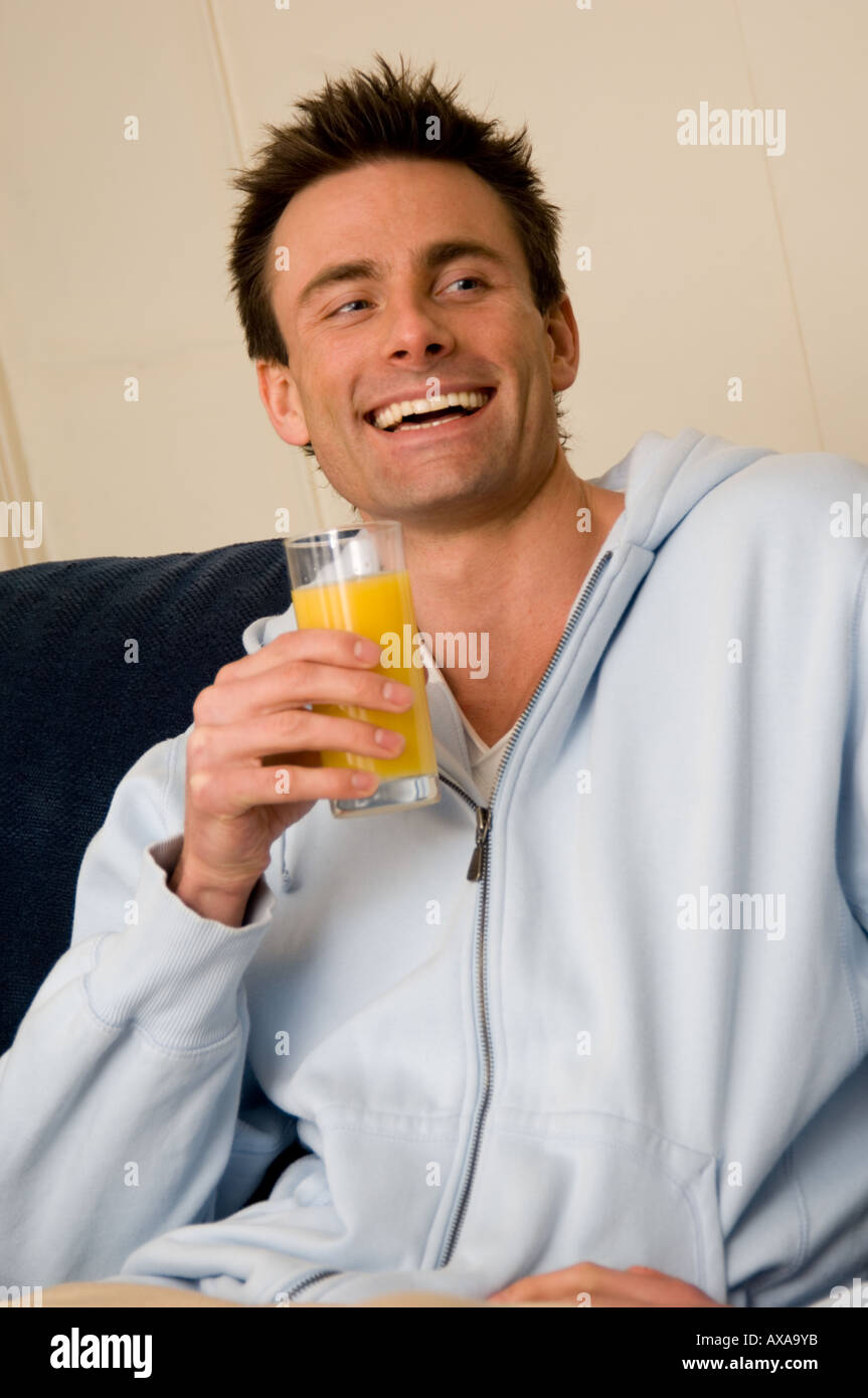 man drinking fresh orange juice Stock Photo