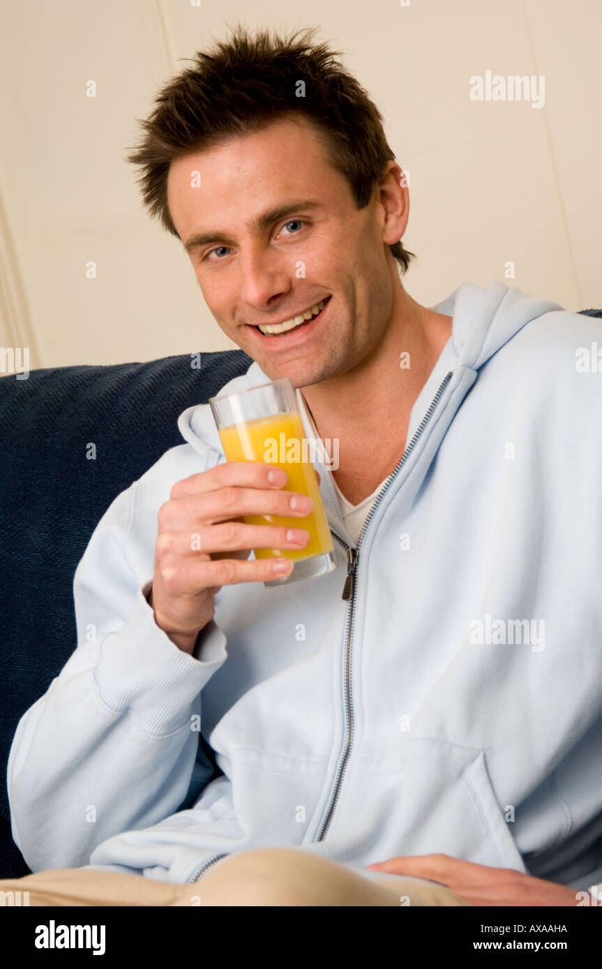 man drinking fresh orange juice Stock Photo
