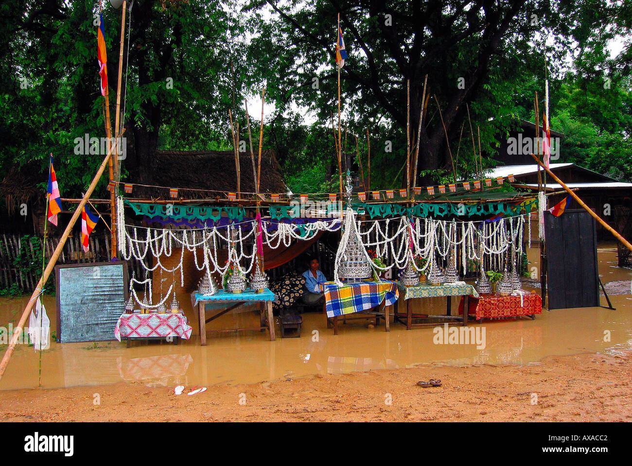 Roadside stall with temple offerings awash but still open for business Burma Myanmar Stock Photo